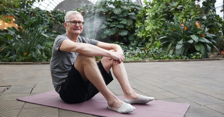 Man sitting on yoga mat