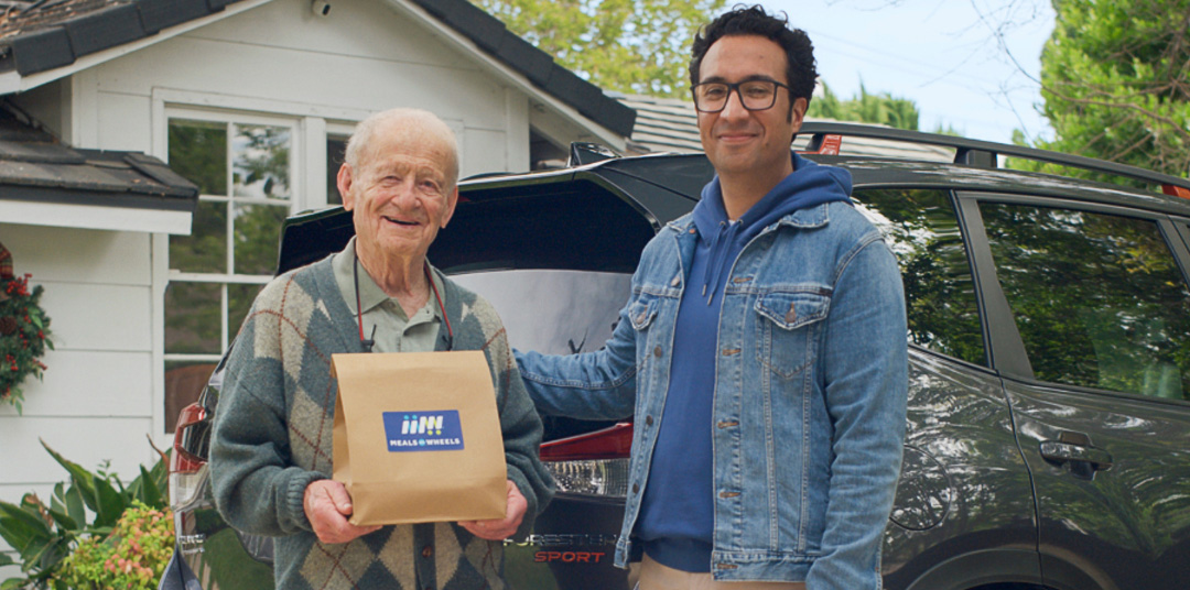 Man delivering meal to older man
